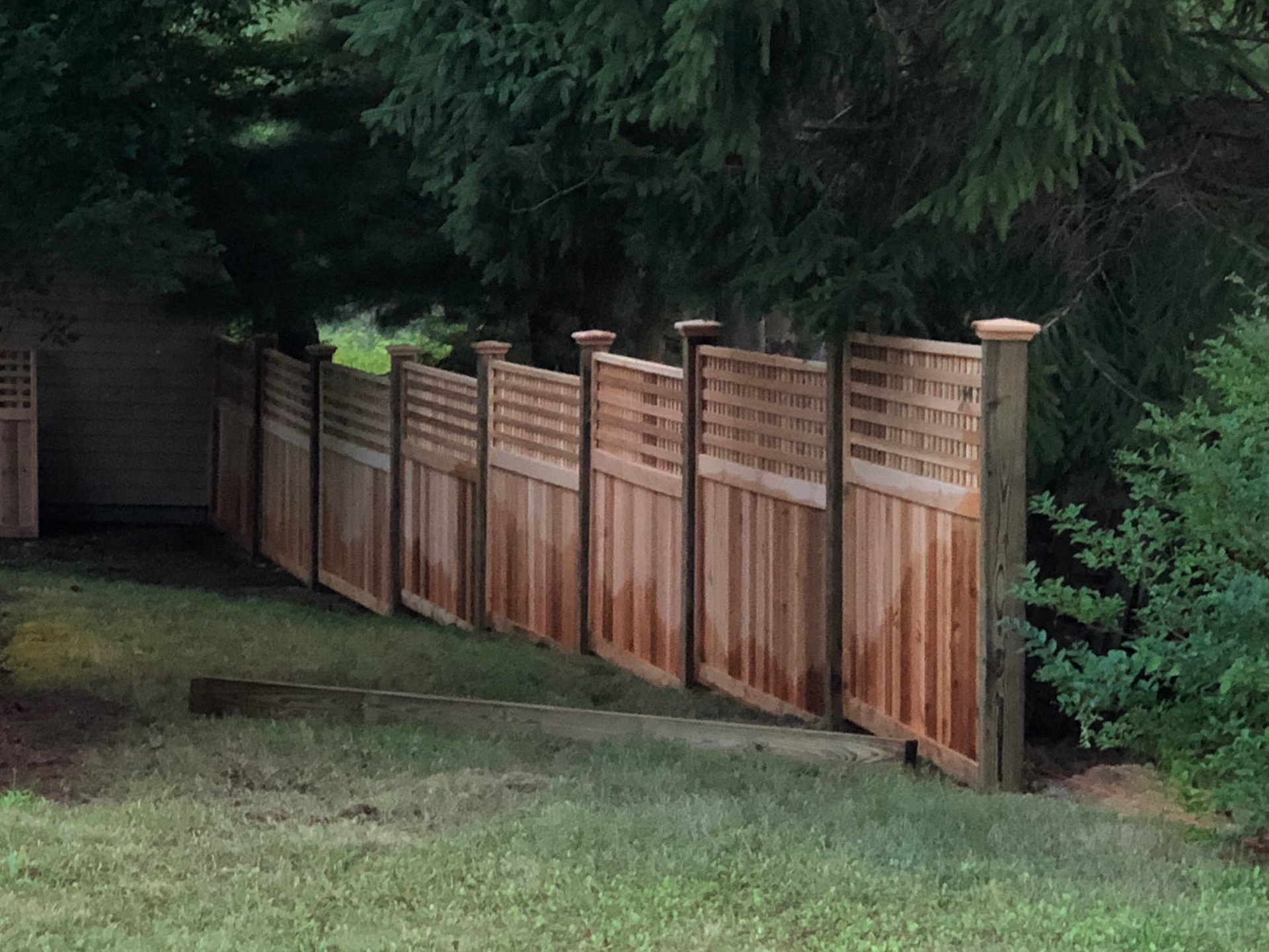 Cedar privacy fence with decorative lattice top and post caps