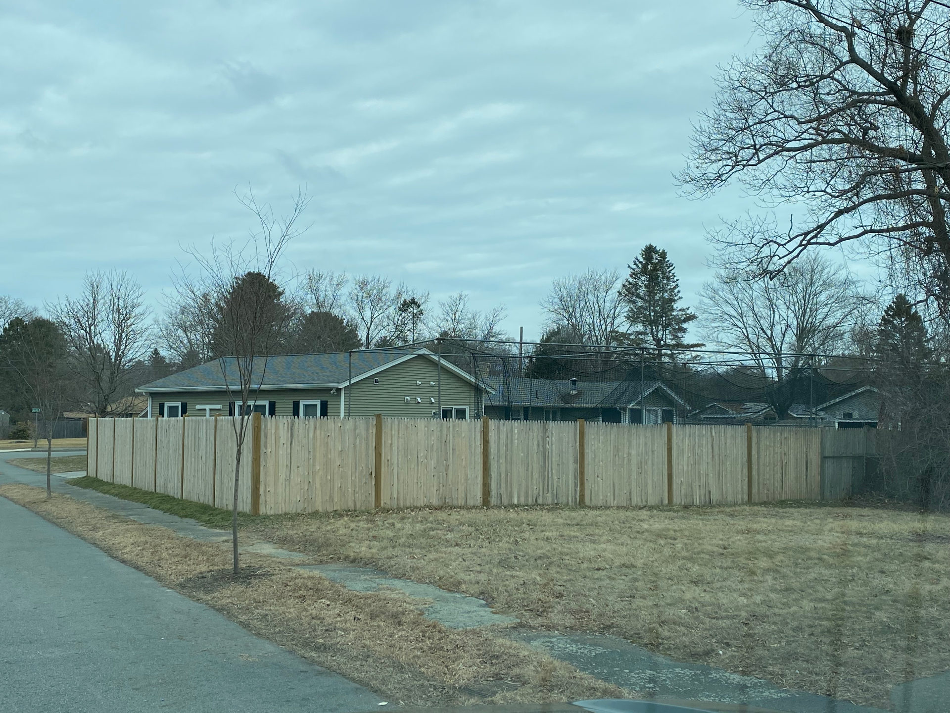 Long stockade cedar fence enclosing a residential backyard