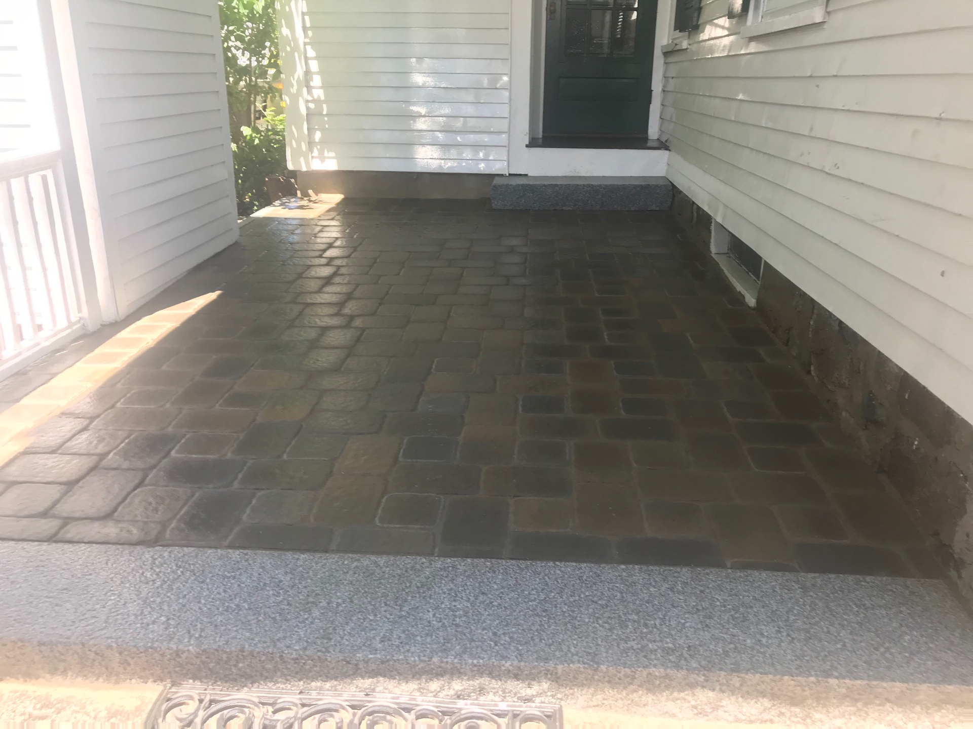 Cobblestone-style paver entry patio with granite step